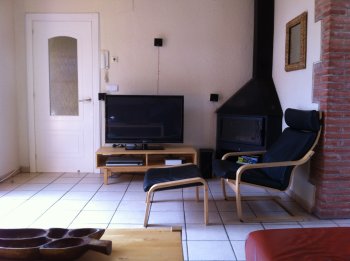 Le salon avec cheminée et équipement audiovisuel